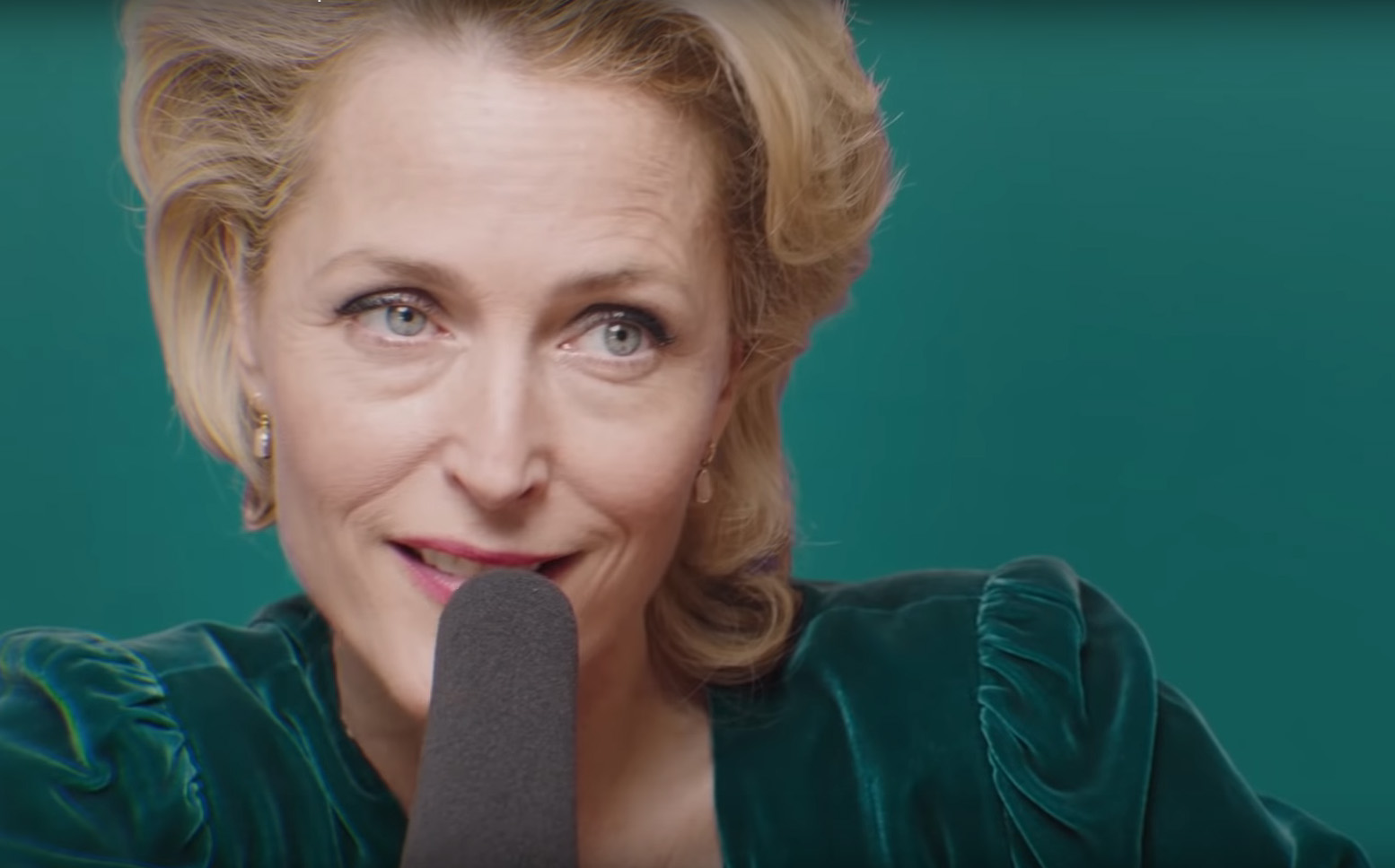 Gillian Anderson sits behind a large microphone