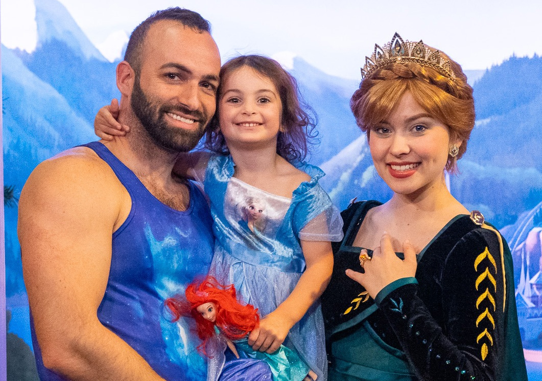 A man and his daughter pose with a Disney princess