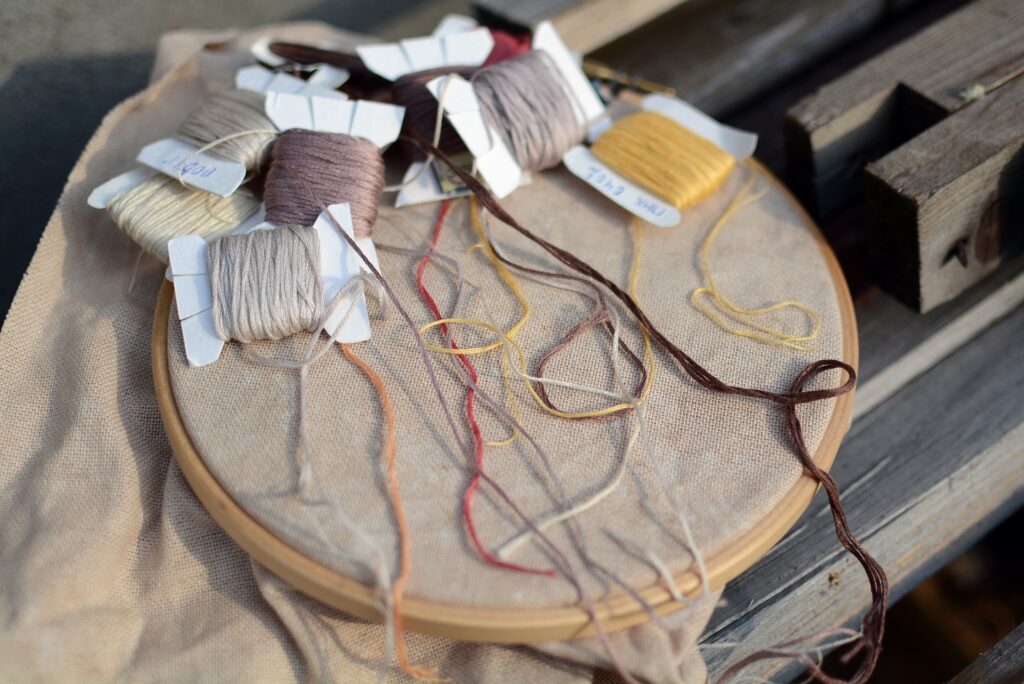 cross stitch hoop and floss on bobbins