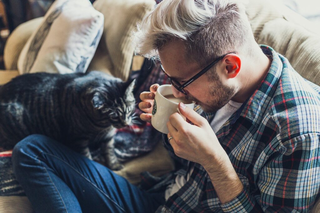 man relaxing drinking coffee with cat