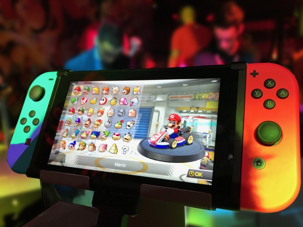 A Nintendo Switch with the image of Mario in a go-cart and several character options beside him